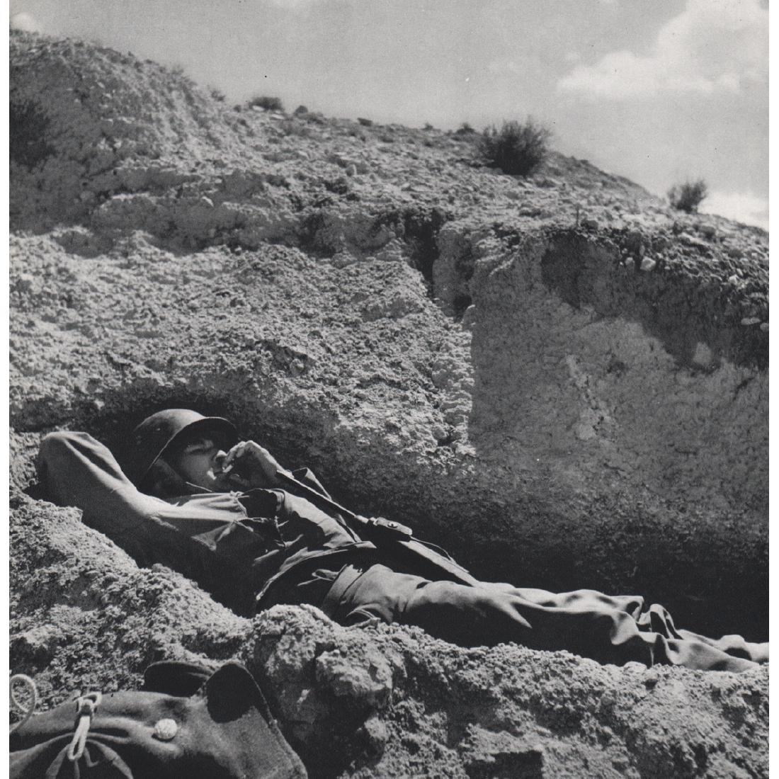 ROBERT CAPA - Soldier resting on a hillside in North: Artist: ROBERT CAPA Print Title: Soldier resting on a hillside in North Africa Medium: Sheet-fed Gravure Printing Date: 1960's Printed in Italy Image Size approx: 9.5 x 10 inches Robert Capa (1913-195