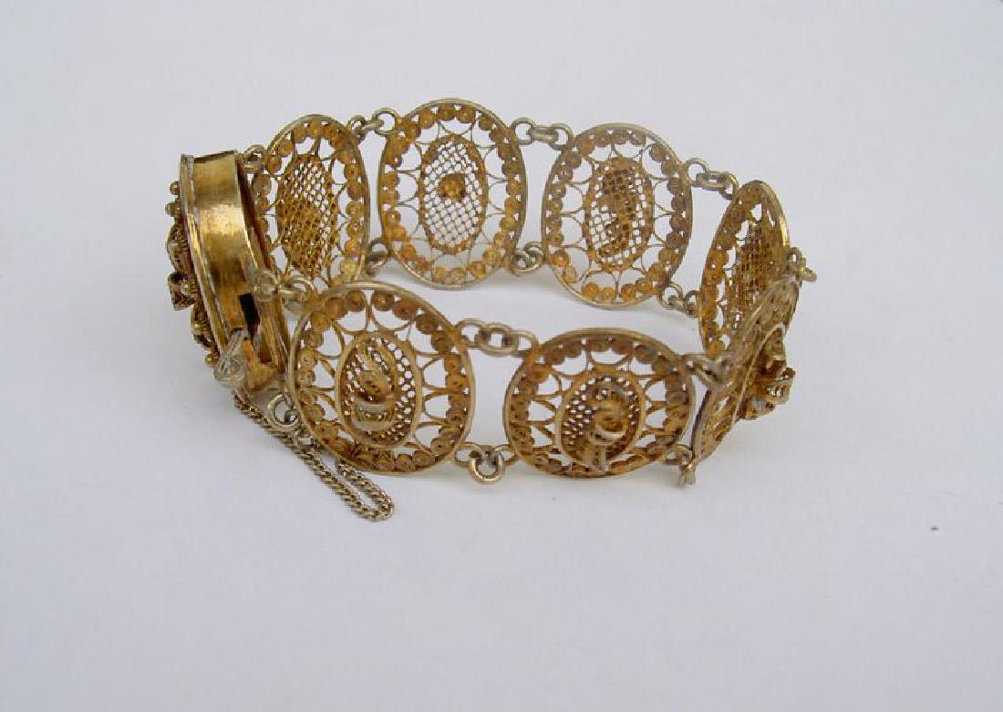 French silver and gilt filigree bracelet, 18th c,: Reserve Reduced! Silver and gilt filigree bracelet with decoration of little ribbons in medallions. The lock with Paris stamp for 1781-89. Security chain later. Length when closed "6 ¼ / 16.5 cm. Con