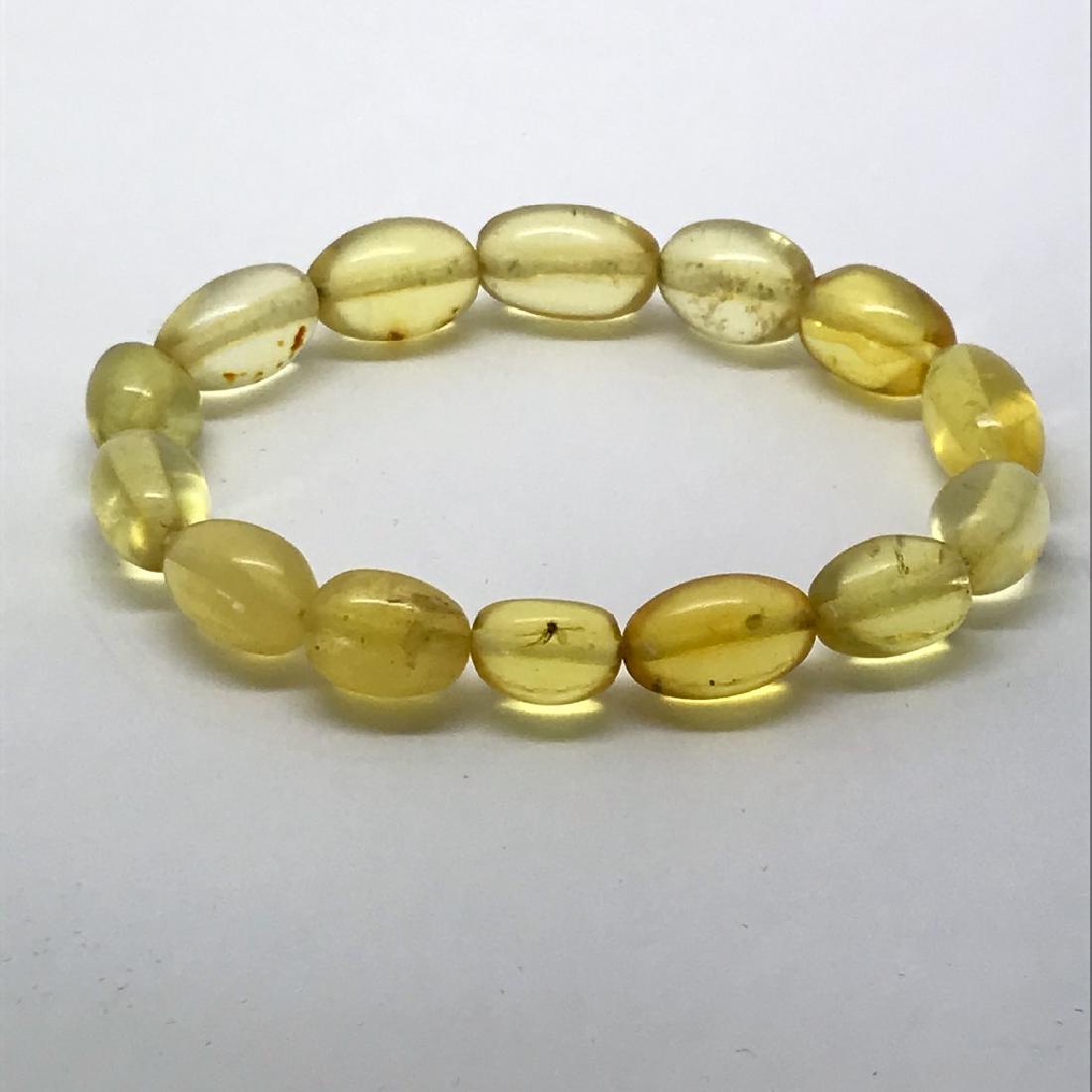 Baltic amber withantique fly inclusion bracelet lemon: Title: Baltic amber withantique fly inclusion bracelet lemon olives Gemstones: Baltic Amber Weight: 7.8 grams Size: olives 10-15mm in length ø8-10mm Additional Information: stretch unisex bracelet, a