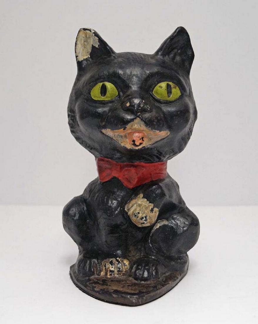 Antique Cat w/ Paw Up Cast Iron Doorstop: Title: Antique Cat w/ Paw Up Cast Iron Doorstop Date: Circa 1920's. Dimensions: 7 3/8" tall x 4 1/4" wide. Additional Information: An Antique Cat with Paw Up Cast Iron Doorstop. Delightful casting wit