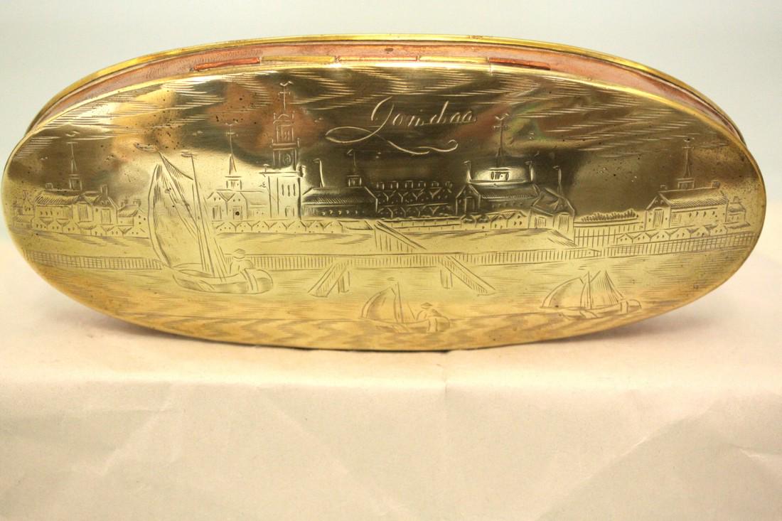 A Late 18th Century Dutch Brass And Copper Ovoid: Title: A late 18th century Dutch brass and copper ovoid tobacco box depicting a harbor scene on one side and a coat of arms on the reverse Date: c. 1780 Measurements: 6 3/4"L x 3/4"W x 1 1/4" H Shippi