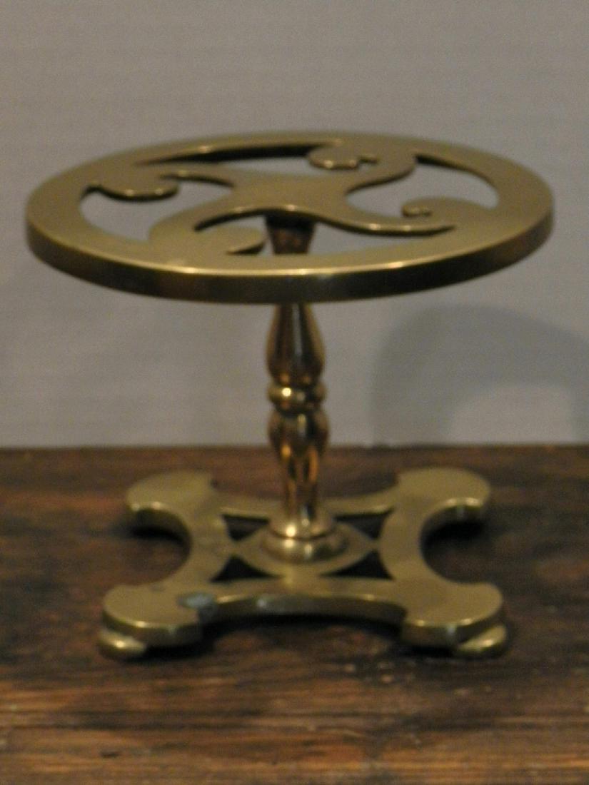 Brass Pedestal Trivet: Title: Brass Pedestal Trivet Dimensions: 4-3/4” Dia x 4-3/4” High Provenance/Additional Information: 19th Century Brass Pedestal Trivet. Shipping: Domestic: Flat-rate of $25.00 to anywhere within