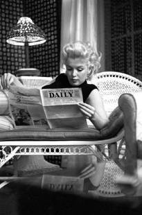 Marilyn Relaxes In A Hotel Room: Artist: Ed Feingersh Title: Marilyn Relaxes In A Hotel Room Medium: Silver Gelatin Year: 1955 Height/Width: 20 x 16 in Description: Actress Marilyn Monroe reads the newspaper ‘Motion Picture