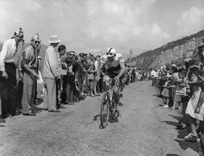 British Rider On Tour: Artist: Bert Hardy Title: British Rider On Tour Medium: Silver Gelatin Year: 1955 Height/Width: 12 x 16 in Description: A British rider on the ninth stage of the Tour de France, between Briancon and M