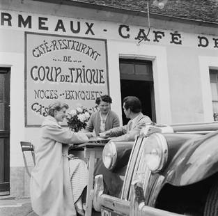 Coup De Trique: Artist: Bert Hardy Title: Coup De Trique Medium: Silver Gelatin Year: 1955 Height/Width: 16 x 16 in Description: A waitress serves coffee to a couple outside the Cafe De Coup De Trique near Le Mans, F