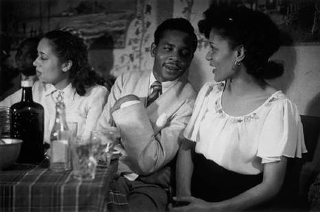 Couple Talking: Artist: Bert Hardy Title: Couple Talking Medium: Silver Gelatin Year: 1949 Height/Width: 12 x 16 in Description: A West Indian couple talking in a bar in Britain.Picture Post – 4825 – Is There A