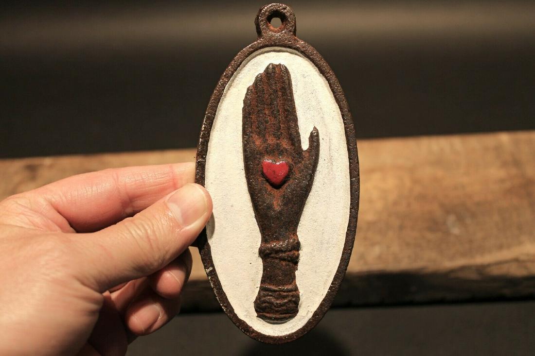 Cast Iron Heart in Hand Odd Fellows Plaque Sign: 5 3/8" height x 2 5/8" Wide A wonderful reproduction cast iron heart in palm sign. Many times the symbol of a heart in an open palm is symbolic of an open welcome or charity. It has also been the symb