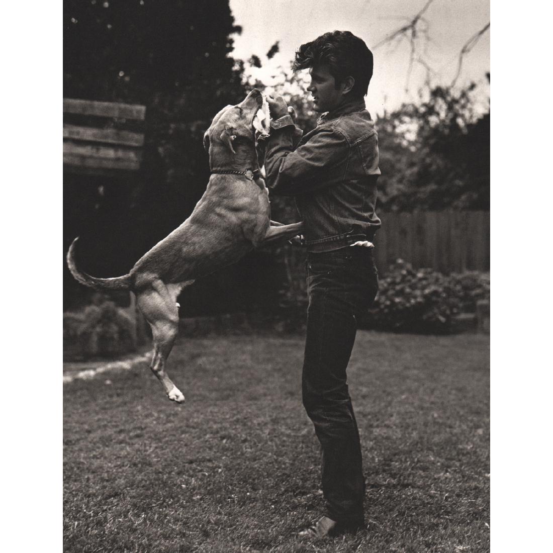 BRUCE WEBER - Chris Isaak and his Dog: Artist: BRUCE WEBER Print Title: Chris Isaak and his Dog, Stockton 1986 Medium: Sheet-fed Gravure Printing Date: 1980's Printed in Spain Image Size approx: 8.5 X 11 inches Bruce Weber is an American f