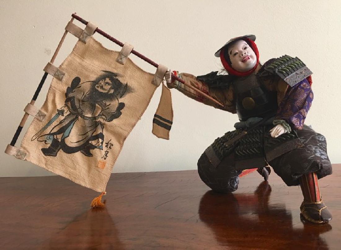 Musha-Ningyo Japan Banner Carrier: Title: Musha-Ningyo Japan Banner Carrier Date/Period: ca. 1915 late Meiji period Origin: Japan Materials: Gofun for the face (ground oyster shell) Brocade silk Paper mache Wood Metal Dimensions: Heigh