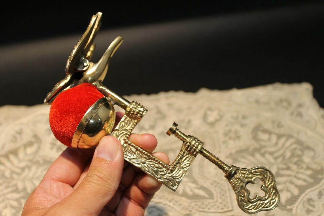 Ornate Brass Sewing Clamp Pin Cushion w Bird Clip: 8" Long x 4" wide the clamp opens to 1 1/8".. so it will fit tables up to 1 1/8" thick. Nice reproduction of an antique solid brass sewing clamp pin cushion with a bird clip. This piece is all solid b