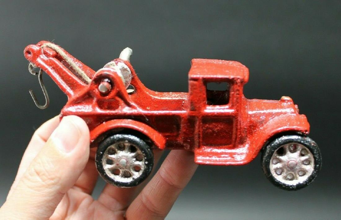 Cast Iron Red Tow Truck Toy Car: 5 1/2" Long x 1 5/8" Wide 2 1/2" Tall Such a rare reproduction tow truck! As you can see this cast iron tow truck was wonderfully hand painted and distressed to look original. The tow truck is mostly 