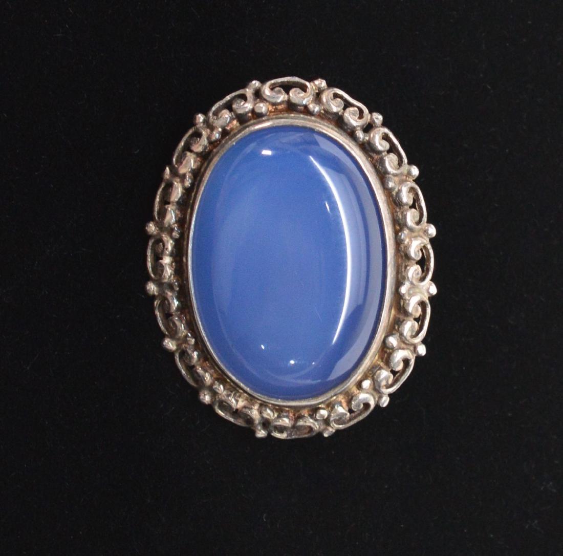Moonstone Cabochon Brooch Pin framed in Sterling Silver: Title: Moonstone Cabochon Brooch Pin framed in Sterling Silver Metal Purity: 925 Gemstones: Moonstone Size/ Dimensions: 1x1-1/4 inch A large twilight hued Moonstone Cabochon that is artistically frame