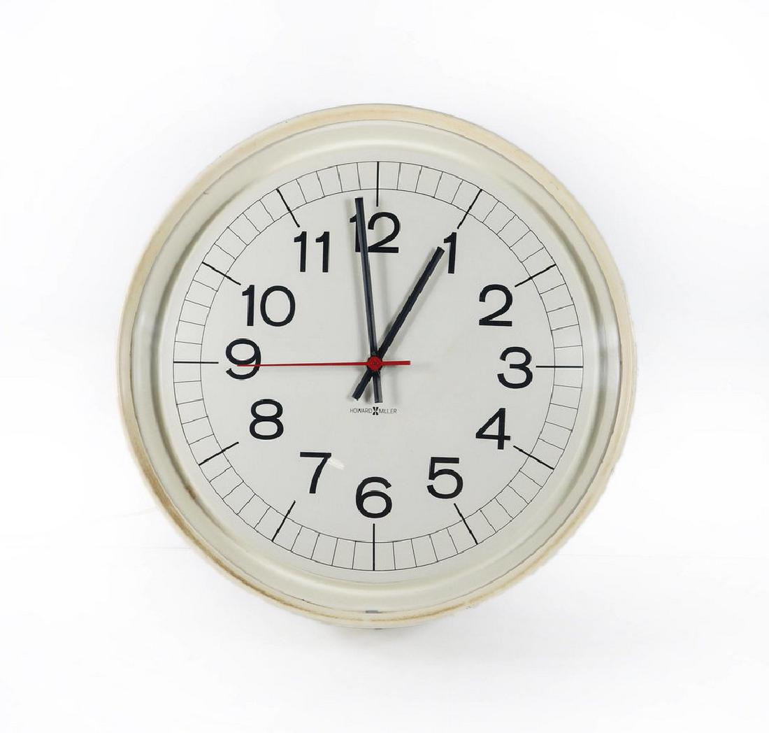 Vintage Howard Miller wall clock: Vintage Howard Miller wall clock with a white metal body and face and black hand and numbers. This clock has a clean mid century modern look that will look perfect in a home, office, or a retail/resta