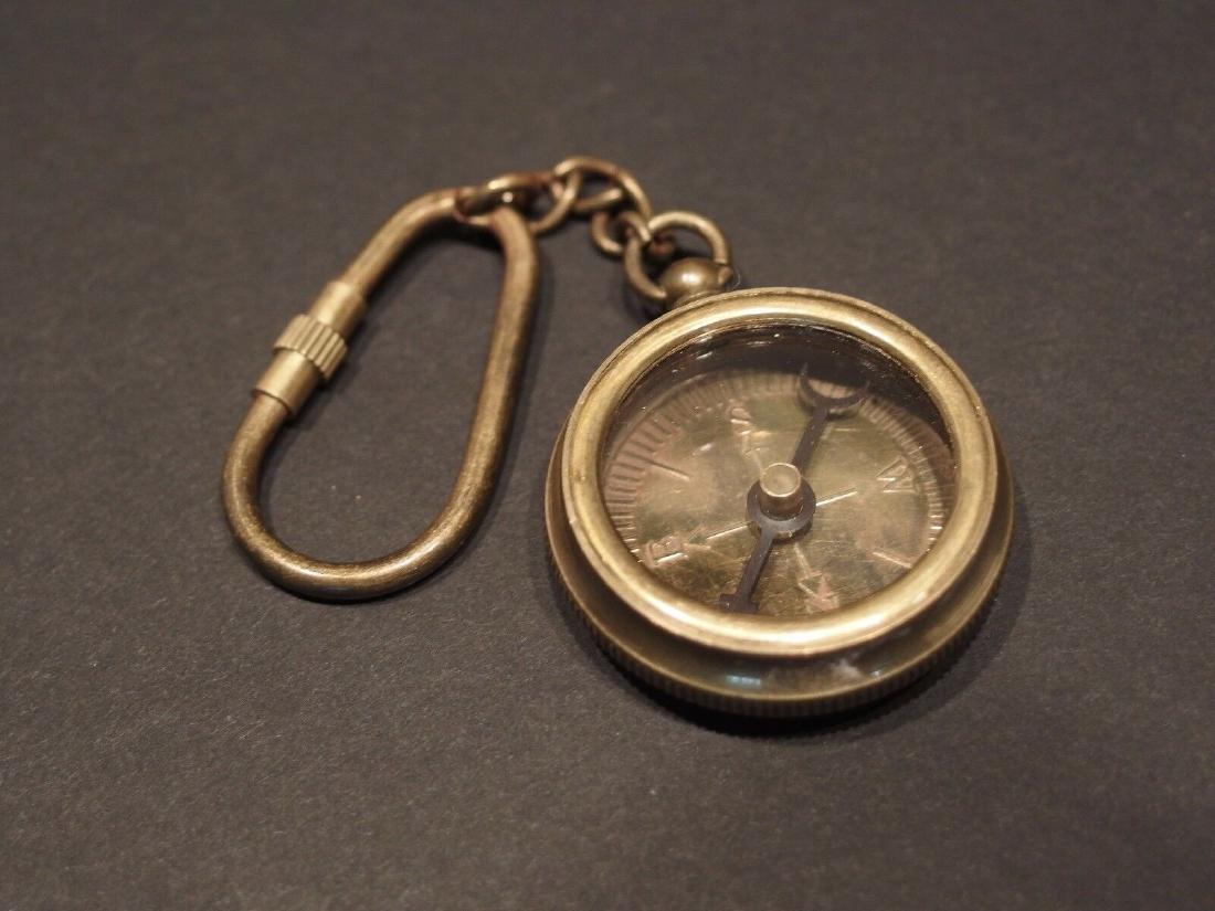 Solid Brass Compass Keychain: 1 3/8" wide Nice reproduction of an antique compass keychain. The compass chain and keychain are all brass distressed to look old. The compass is a standard magnetic compass all the letter and marking