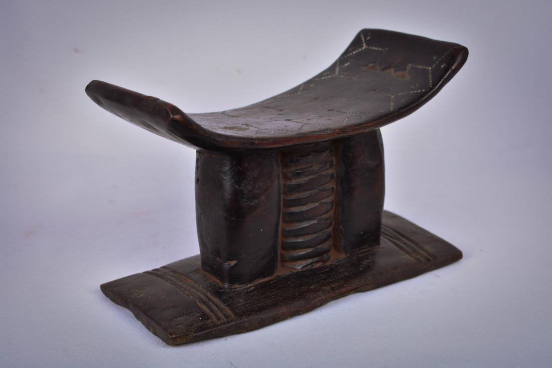 Neck rest – Wood – Asante – Ghana: The Asante stool is the most important and symbolical complex of all Asante art forms: the stools have multiple forms, functions and meanings. They range, in significance, from everyday furniture to a