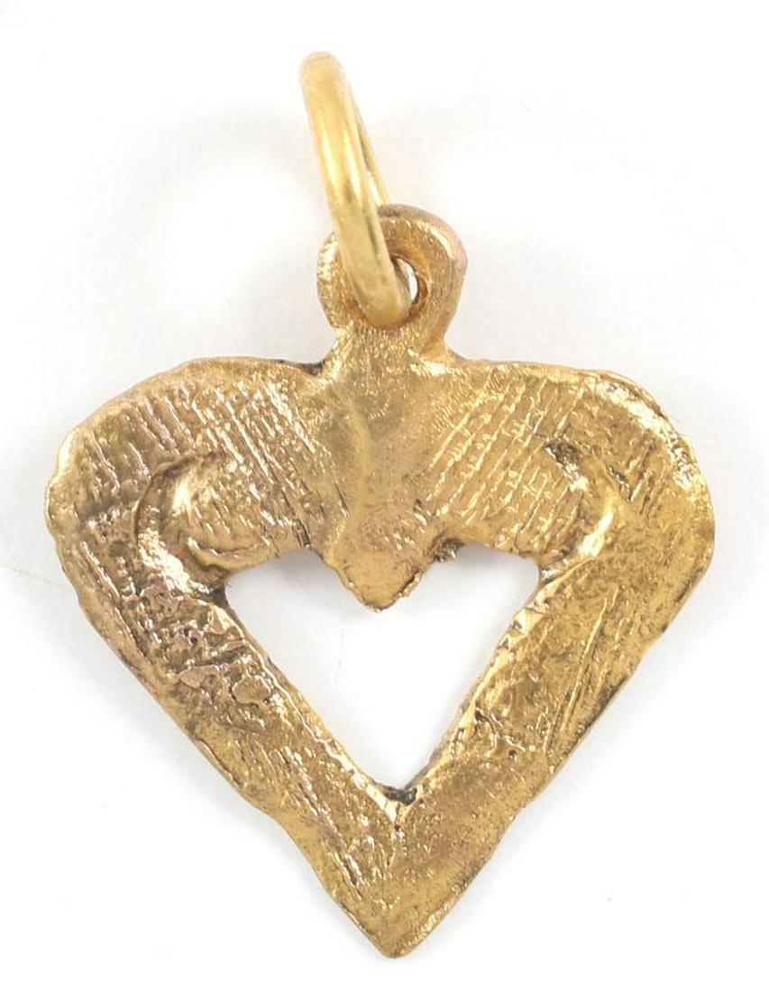 VIKING HEART PENDANT C.900-1050 AD.: 3/4” height. Made by the open mold process. Iconic fully developed form with cusped top and broad edges. The field opened (pierced) with small foliate scrolls at the shoulders. The heart stood for b