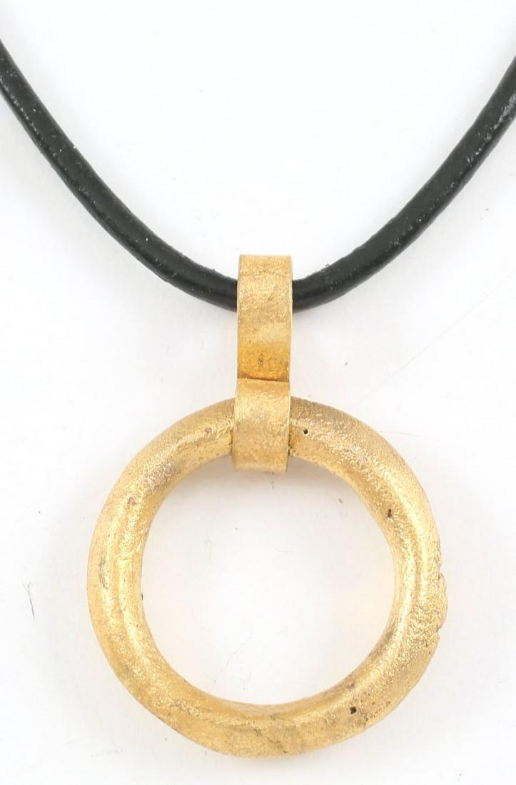 VIKING PROTECTIVE BROOCH 850-1000 AD: Gilt bronze, just under 1" diameter. Circular, with front, back and outer edge ridged. A little worn and textured from burial. Worn in numbers on the surface of the jerkin, these small metal brooches 