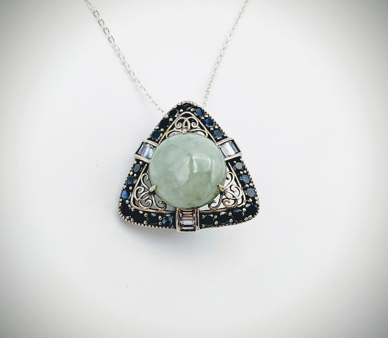 Necklace & Triangular Pendant w Jade, Spinel & CZs: Title: Necklace & Triangular Pendant w Jade, Spinel & CZs Brand: Jean Lin Collection Metal Purity: 925 Sterling Silver Gemstones: Jade, Spinel & Cubic Zirconia Carat Weights: Pendant has 1 Round Jade 