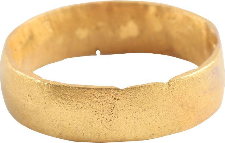 VIKING WEDDING RING: Late 9th-early 11th century AD. Gilt bronze, size 6 ¼. A broad band with a rounded face. The inside with distinct tool marks from a removal of the central core after casting. Professionally refurbish