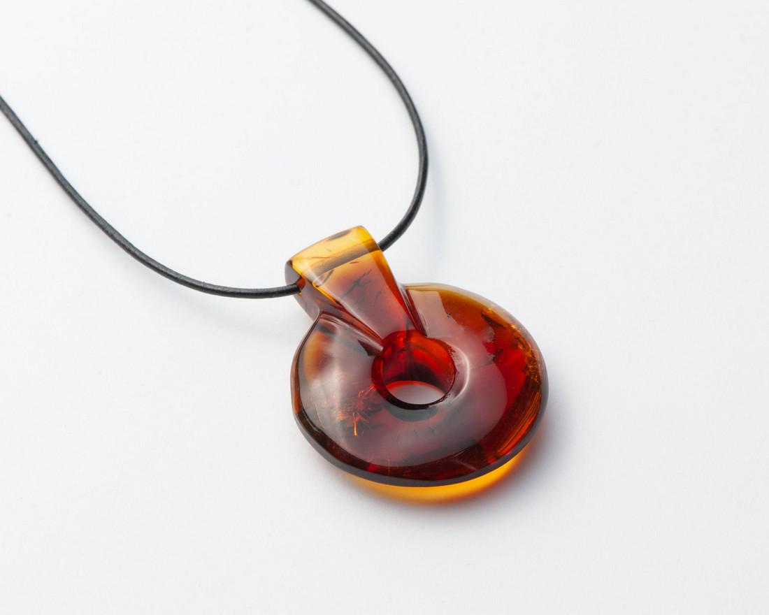 Caribbean Green Amber Necklace: Title: Caribbean Green Amber Necklace Materials: Caribbean Green Amber Weight in grams: 9.64 Additional Information: Caribbean Green Amber Necklace. Black leather. Donut shaped. Cognac color. Reserve: