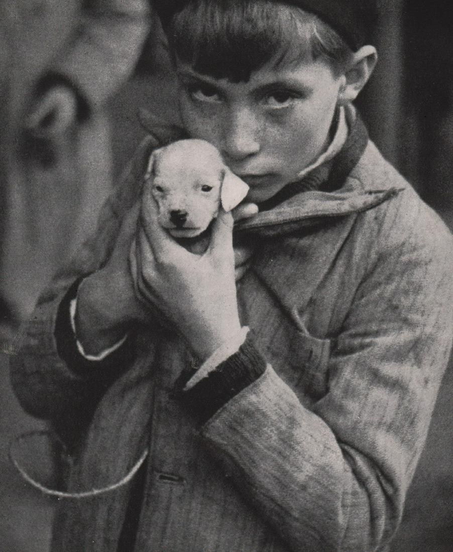 KERTESZ - Boy & his puppy: Artist: KERTESZ Print Title: Boy & his puppy Medium: Photoengraving Printed 1940’s in the USA Image size (inches) approx. 7.5 x 6.5” Andre Kertesz (1894-1985) born Kertesz Andor, was a Hungarian