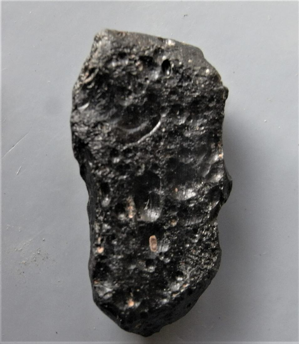 THAILANDITE TEKTITE - FROM METEORITE IMPACT: Title: THAILANDITE TEKTITE - FROM METEORITE IMPACT Origin: Noen Sa-nga. Chaiyaphum Prov. Thailand Size: 2.8x1.4x0.75 cm / 5 gram Description: elongate, flattened and pitted thailandite tektite with fl