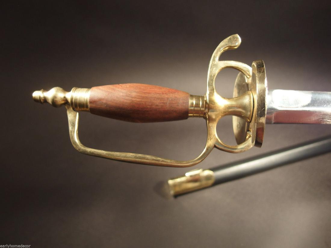 French Hanger Cutlass Sword Brass Wood French Indian: 43" Long with scabbard 38" overall 30 1/2" V blade 4" Wood handle Similar to the replica Antique English Hanger we offer, this piece is the French Hanger Replica c1730-1750 wood handle, solid brass so