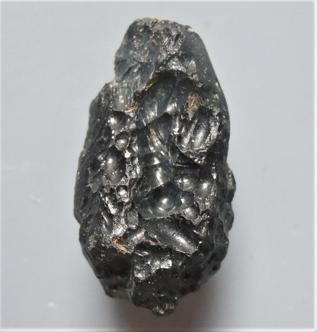 THAILANDITE TEKTITE - FROM METEORITE IMPACT: Title: THAILANDITE TEKTITE - FROM METEORITE IMPACT Origin: Noen Sa-nga. Chaiyaphum Prov. Thailand Size: 2.2x1.3x1.2 cm / 5 gram elongate rounded thailandite tektite with gooves and flow lines Reserve: