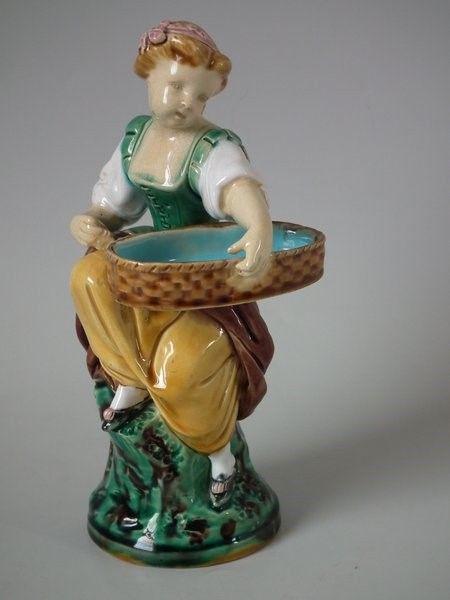 Minton Majolica Hogarth girl match holder figure: Title: Minton Majolica Hogarth girl match holder figure Description: Minton Majolica Hogarth girl match holder figure Description Minton Majolica match holder which features a Hogarth girl, sat on a r