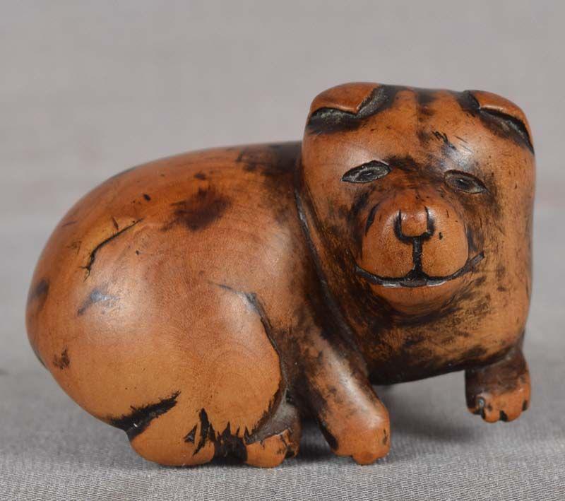 19c netsuke RESTING smiling PUPPY: 19th century boxwood netsuke of a resting puppy with its head turned to the right. Very nicely carved, great depiction of its slightly chubby body and almost human smiling face. Very pleasant wear and