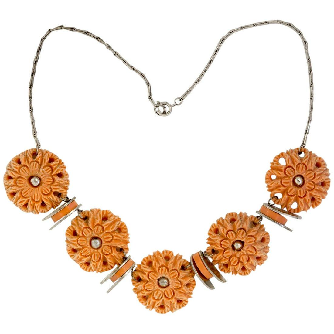 1930's Jakob Bengel Unusual Peach Galalith Medallion: A lovely and unusual Jakob Bengel floral motif necklace. It is comprised of 5 peach color galalith medallions, each with a central flower pattern surrounded by intricate detailing. In turn, each disk