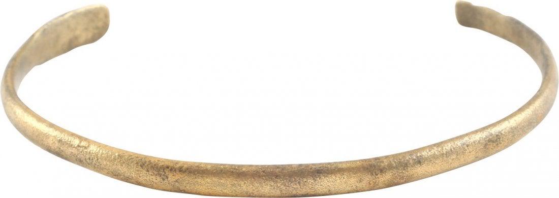 VIKING WOMAN'S BRACELET, 9TH-10TH CENTURY AD.: VIKING WOMAN’S BRACELET, 9TH-10TH CENTURY AD.Gilt bronze, open oval or C form, 2 3/8” inside dimension. A thick section with a rounded face slightly tapering toward the ends which are fashioned as