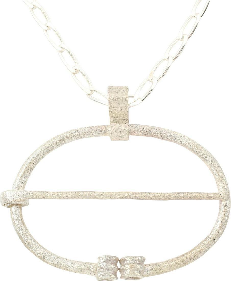 VIKING PROTECTIVE BROOCH 850-1050 AD: 1 3/4” width, oval form with the ends deeply reeded and curled. Original cross pin. Worn in numbers on the leather war jerkin, at an ounce each, a few pounds could be added providing significant pro