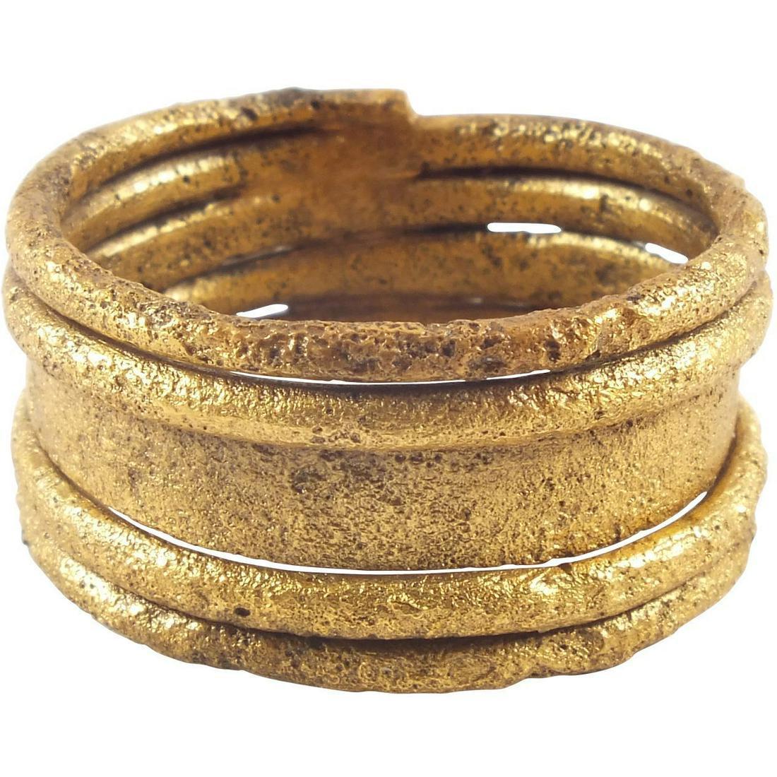 FINE VIKING WARRIOR’S RING 10th CENTURY: Refinement of the coil form which was very popular with a medial flat tapering to circular section windings which flank it. Size 10. Bronze, professionally refurbished with the gold surface restored. 