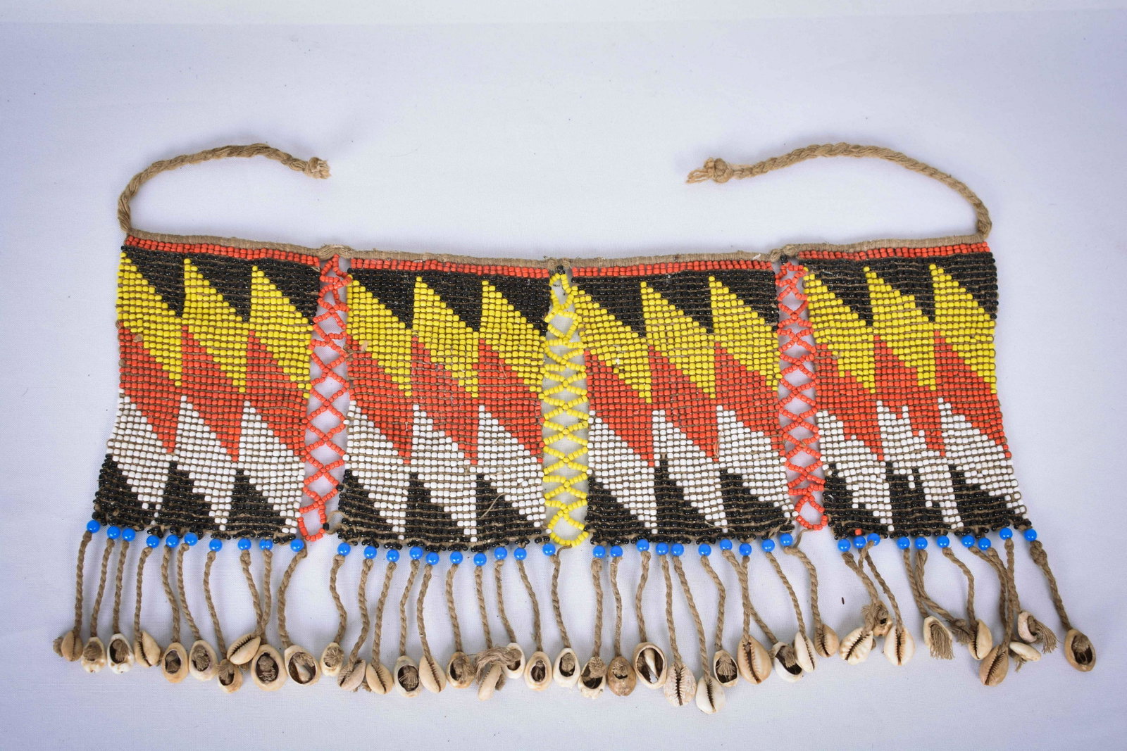 Pubic Apron – Beads, Shells – Cache-sexe – Kirdi –: The Kirdi inhabit the mountain area in northern Cameroon and eastern Nigeria. The Fali, Bana, Kapsiki and Guilli belong to this population group. The women and girls wear pubic cloths that are made of