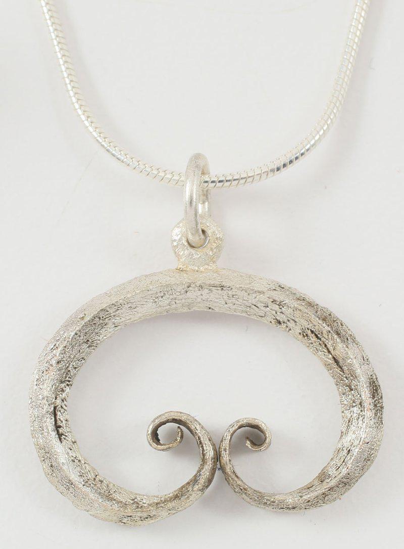 FINE VIKING LUNAR/ASTROLOGICAL PENDANT C.900-1050 AD.: Silvered bronze, slightly under 1” width. Crescent form, of diamond section, with scrolled terminals, probably representing Sol the sun and Mani the moon. Significantly, the terminals touch before s