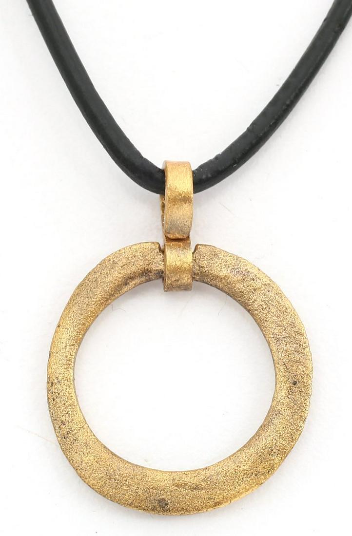 VIKING PROTECTIVE BROOCH 9th-10th CENTURY: Gilt bronze, slightly over 7/8” diameter of rounded form with sharp edge, half rounded face and flat back. Worn in numbers on the surface of the jerkin, these metal brooches provided a measure of pr
