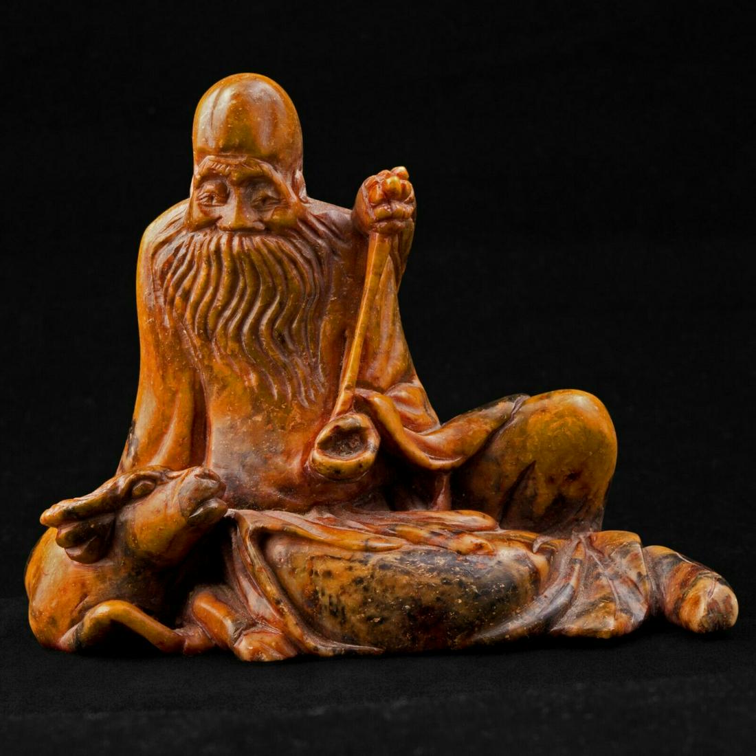 Chinese Soapstone Carving Shoulao c 1900: Soft smooth great carving of Chinese Daoist God Shoulao, the God of longevity. Soapstone color is tan with dark brown and reddish spotting. The carving is very good. The beard, the clothing folds, the