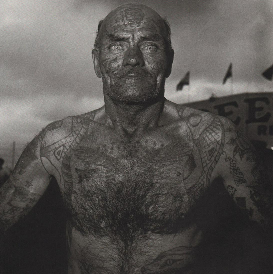 DIANE ARBUS - Tattooed Man at a Carnival, MD, 1970: Artist: DIANE ARBUS Print Title: Tattooed Man at a Carnival, MD, 1970 Medium: Photoengraving Printed 1970’s in the US Image size (inches) approx. 8 x 8” Diane Arbus (1923 –1971),was an American 