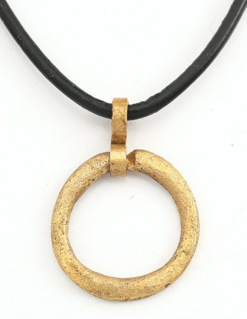 VIKING PROTECTIVE BROOCH 850-1000 AD.: Gilt bronze, about 7/8” diameter. Rounded face and oval section. Worn in numbers on the surface of the jerkin, these small metal brooches provided a measure of protection against sword cuts and, in 