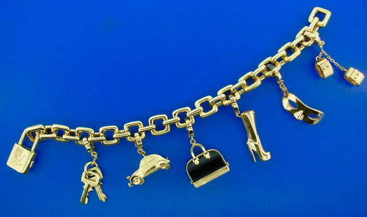 HEAVY AND CHIC Louis Vuitton 18k Yellow and Onyx Gold: AK J0T00 Louis Vuitton 18k Yellow Gold and Onyx Bag, Mask, Handcuff, Lock, Boot, Car Charm Bracelet · Wonderful bracelet by Louis Vuitton that is a great addition to your collection. · Weight is
