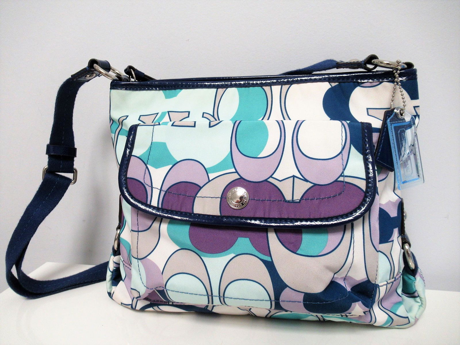 Coach canvas shoulder bag: Title: Coach canvas shoulder bag Materials: Canvas Dimension: Size Medium. MEASURES: L 30 cm, H 23 cm, P 6 cm. Adjustable shoulder strap. Provenance:"Coach" canvas shoulder bag. In shades of blue, pur