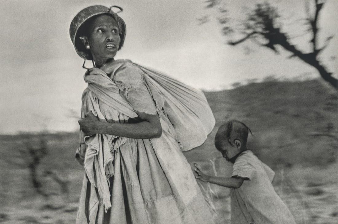 SEBASTIAO SALGADO - Looking For Planes Blocking Escape: Artist: Sebastiao Salgado Title: Woman Searches for Planes Blocking Escape, Ethiopia Medium: Photo Litho, 1999, Italy Dimensions: 9.65x6.4" Heat Wax Mounted on 11x14" Conservation Board Sebastiao Salg