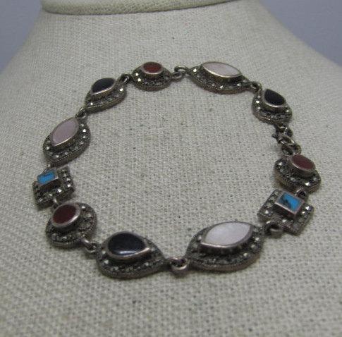 Vintage Sterling Marcasite Inlaid Bracelet, MOP,: Vintage Sterling Marcasite Inlaid Bracelet, 7.75" and 1/2" wide with raised inlaid onyx, pink mother-of-pearl, carnelian, and turquoise. There are no marcasites missing and all stones are original. It