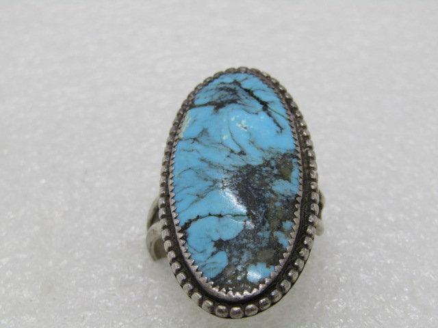 Vintage Southwestern Sterling Silver Turquoise Ring,: Vintage Sterling Southwestern Turquoise Ring, Adjustable, Unisex - size 8-10. 11.87 grams 1.5" Oval Stone. It is 3/4" wide. 1970's. Sawtooth bezel set with rope accent base that is slightly wider than