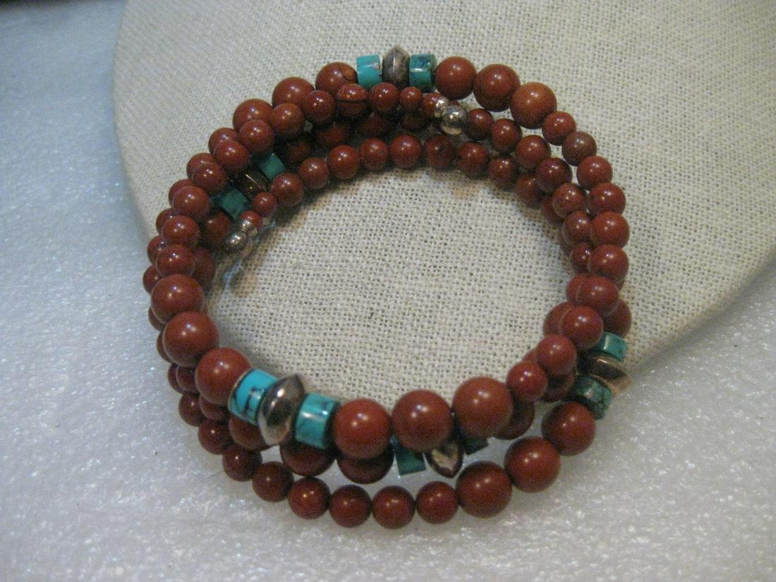 Southwestern Sterling Silver Carnelian & Turquoise: Sterling Silver Southwestern Coiled Bracelet with graduated carnelian beads and turquoise tube beads with sterling silver end beads and rounded ridged beads. The smallest carnelian beads are about 4mm
