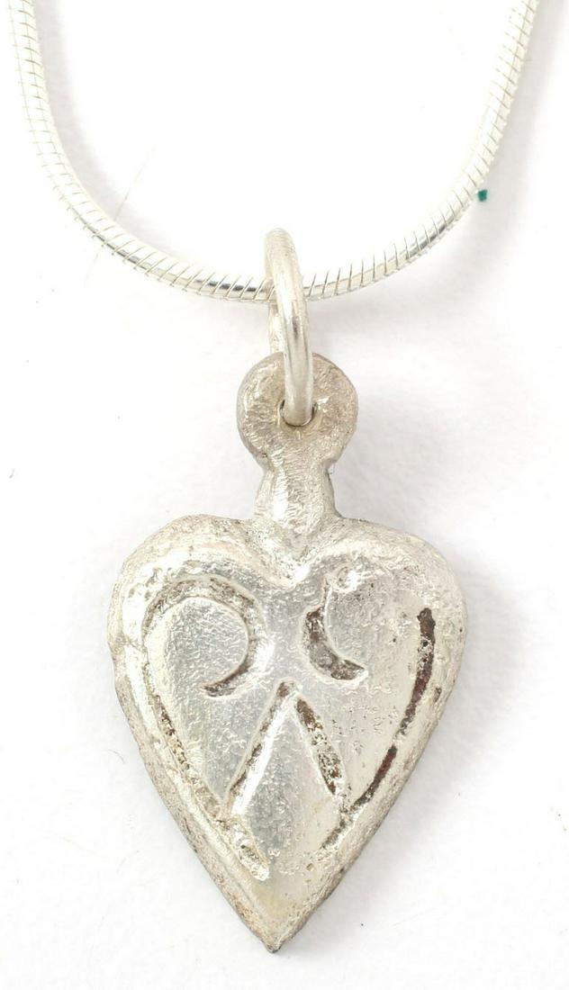 VIKING HEART PENDANT C.900-1000 AD.: Early example of the fully evolved form with cusped top and near rounded sides. Slightly domed with large central trefoil motif, the upper members comprising the scrolled border terminal. Just over 7/