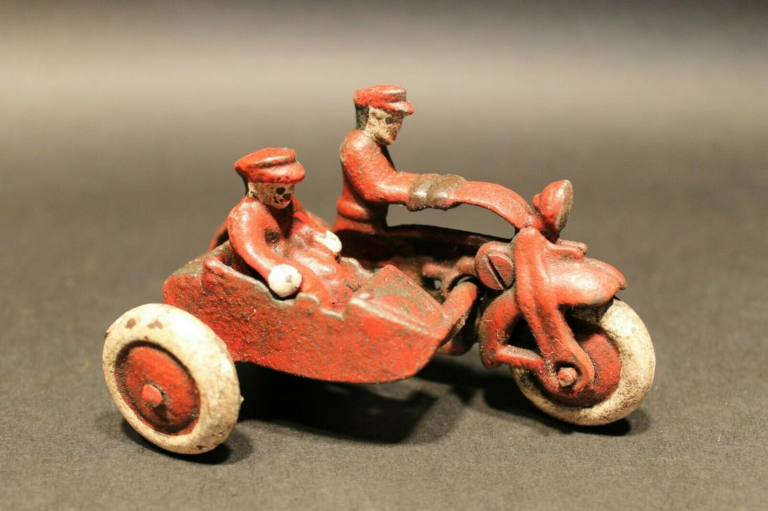 Cast Iron Toy Motorcycle with side car 2 riders: 4" Long x 2 1/4" wide Such a neat reproduction cast iron motorcycle! As you can see this heavy cast iron pull toy motorcycle was wonderfully hand painted and distressed to look like an original antiqu