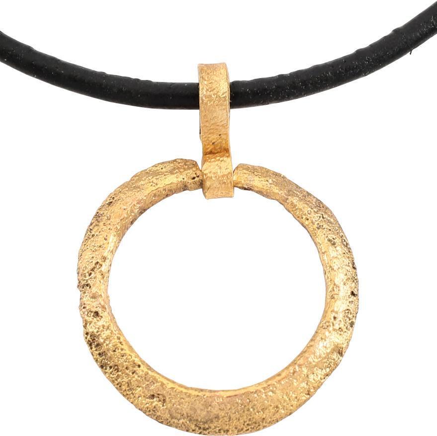 VIKING PROTECTIVE BROOCH PENDANT, 10TH CENTURY: Circular bronze, just under 1Â” diameter with a cylindrical center, and beveled face meeting the flat back as an outer ridge. The surface with light texture from burial. Professionally conserved an