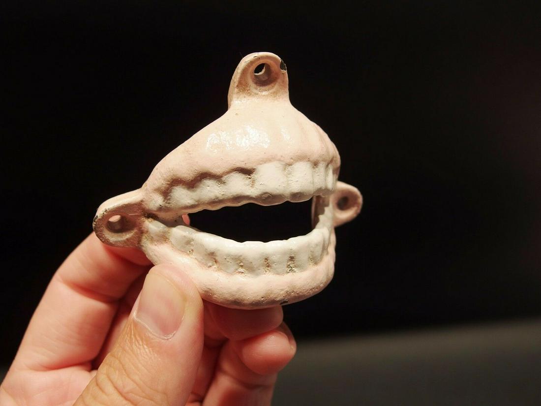 Cast Iron Folk Art Beer Cap Teeth Wall Mount Bottle: 3 1/8" Wide 2 1/4" Tall Great reproduction cast iron bottle opener. This piece was made to look just like an antique, but is new. Reserve: $13.00 Shipping: Domestic: Flat-rate of $7.00 to anywhere wit